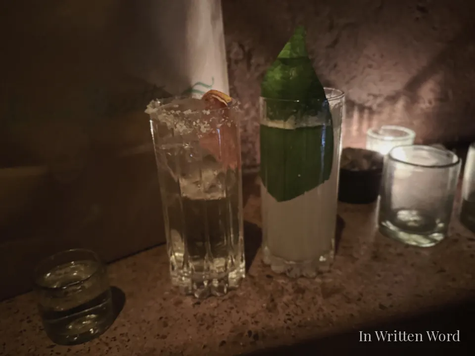 Mezcal cocktails at Tlecān bar in Mexico City served in tall glasses under warm candlelight.